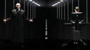 Die Pet Shop Boys auf der Bühne: Das Bühnenbild ist dunkel gehalten, beide sind schwarz gekleidet. 