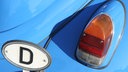 Koflügel eines hellblauben VW Käfer mit Deutschlandschild und Rückleuchte