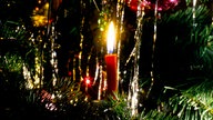 Weihnachtsbaum mit roter Kerze und Lametta