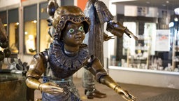 Der Aachener Puppenbrunnen: Eine Puppe steht im Fokus, im Hintergrund sind weitere Figuren zu sehen.