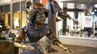 Der Aachener Puppenbrunnen: Eine Puppe steht im Fokus, im Hintergrund sind weitere Figuren zu sehen.