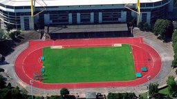 Eine Luftaufnahme vom Stadion Rote Erde. In der Mitte befindet sich ein Fußballfeld, darum verläuft eine rote Laufbahn. Am oberen Rand des Bildes sieht man einen Teil einer Seite des Westfalenstadions.