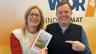 Buchcover: "Kala" von Colin Walsh wird von Ute Schneider in die Kamera gehalten