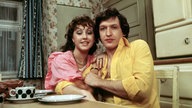 Hildegard Krekel (als Rita) und Diether Krebs (als Rita's Ehemann Michael) am Küchentisch bei den Dreharbeiten der ARD-Serie "Ein Herz und eine Seele" (1974)