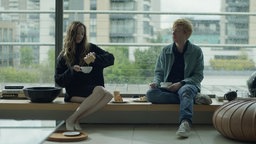 Alice (Andrea Riseborough) und Jack (Domhnall Gleeson) aus der Serie "Alice & Jack" sitzen vor einem Fenster und frühstücken zusammen