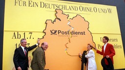 Vier Personen schieben am 30. Juni 1993 vor dem Berliner Rathaus symbolisch für die Einführung der neuen fünfstelligen Postleitzahlen eine große Deutschlandkarte zusammen