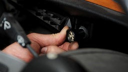 Ein Choke in einem Oldtimer wird betätigt, um das Auto zu starten