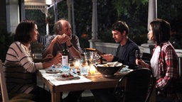 Szene aus dem Film "Die kanadische Reise": Die Familie Pierres sitzt mit Mathieu an einem gedeckten Esstisch.