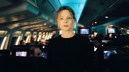 Szene aus dem Film "Flightplan – Ohne jede Spur": Schauspielerin Jodie Foster steht im Mittelgang eines spärlich beleuchteten Flugzeuges