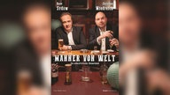 René Sydow und Christian Miedreich des Kabaretts "Männer von Welt" sitzen mit Bier, Schnaps und Zigarre am Tisch in einer Kneipe