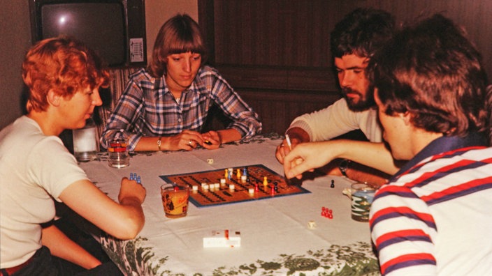 70er Jahre: Mehrere Menschen spielen das Spiel "Malefiz"