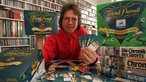Willi Andresen hält in seinem Hamburger Büro eine Ausgabe von Fragen und Antworten für das Spiel "Trivial Pursuit" in den Händen (1997)