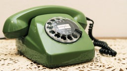 Ein grünes Telefon mit Drehscheibe