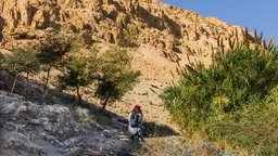 Eine junge Frau wandert auf einem Pfad durch die zerklüfteten Hügel des Naturreservats Ein Gedi