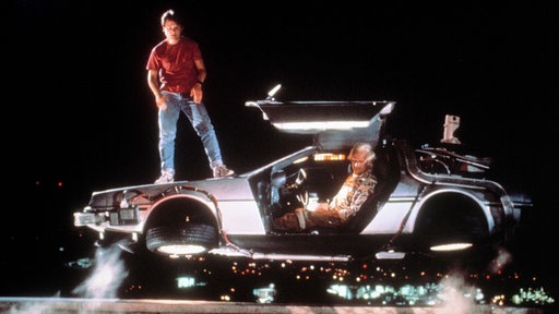 Szene aus dem Film "Zurück in die Zukunft": Schauspieler Michael J. Fox und Christopher Lloyd mit dem Zeitreise-Auto