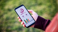 Ein Mann hält ein Handy und nutzt eine Fitness-App, die Schritte zählt