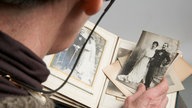 Ein Mann blättert in einem älteren Fotoalbum