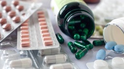 Verschiedene Arzneimittel in Form von Tabletten liegen in unterschiedlichen Packungen oder lose durcheinander