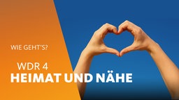 Zwei Hände formen ein Herz vor dunkelblauem Himmel