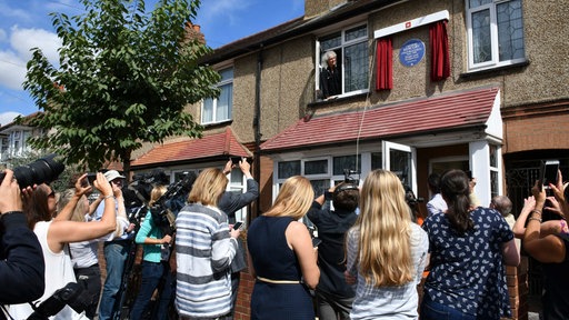 Eine Menschenmenge wartet vor dem ehemaligen Wohnhaus Freddie Mercurys in Feltham bei der Enthüllung der Blauen Plakette