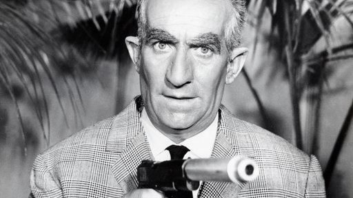 Szene aus dem Spielfilm "Fantomas": Inspektor Juve (Louis de Funès) hält einen Revolver in der Hand