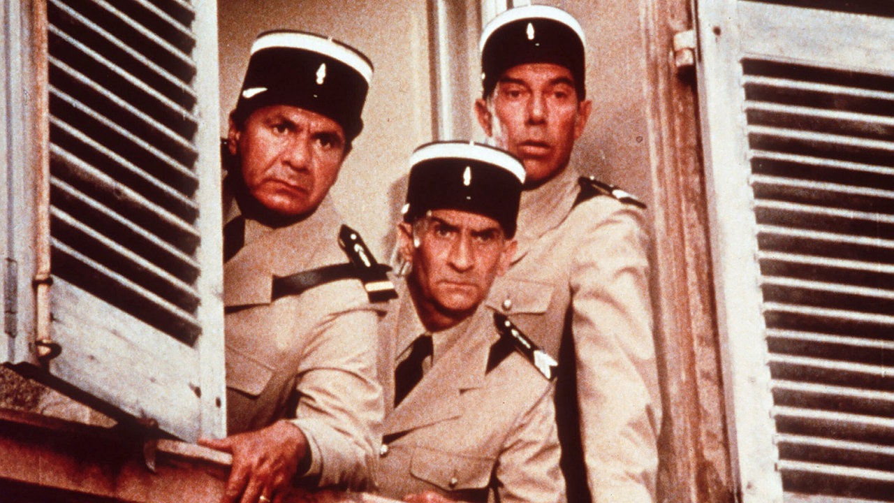 Szene aus "Louis' unheimliche Begegnung mit den Außerirdischen": Louis de Funès und seine Schauspielkollegen Michel Galabru und Maurice Risch schauen als Gendarm verkleidet grimmig aus dem Fenster