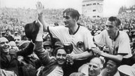 Fritz Walter und Horst Eckel werden anch dem Triumph von Anhängern vom Spielfeld getragen
