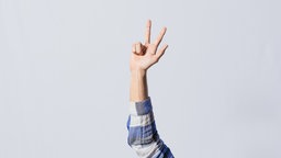 Eine Hand, die drei Finger ausgestreckt hat