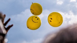 Smiley-Ballons fliegen in die Luft
