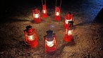Im Kreis aufgestellte leuchtende Grubenlampen, die aussehen, wie das Geleucht auf dem Gipfel in Miniaturformat
