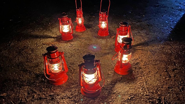 Im Kreis aufgestellte leuchtende Grubenlampen, die aussehen, wie das Geleucht auf dem Gipfel in Miniaturformat