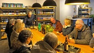 Mehrere Gäste sitzen bei einem Bier-Tasting am Tisch