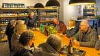 Mehrere Gäste sitzen bei einem Bier-Tasting am Tisch