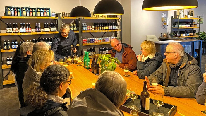 Mehrere Gäste sitzen bei einem Bier-Tasting am Tisch