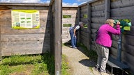 Zwei Personen nutzen die Beobachtungsstation auf einem Aussichtshügel in den Lippe-Auen bei Hamm 
