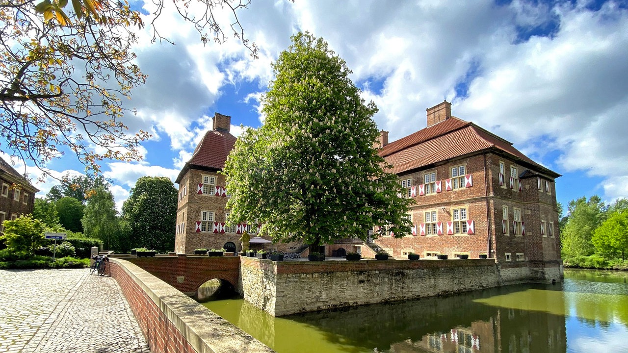 Das Wasserschloss Oberwerries von außen unter blauem Himmel mit ein paar Wölkchen