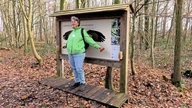 Wandern rund ums Schloss Nordkirchen: Eine Person steht vor einem Infostand mit nachempfundener Flügel-Spannweite diverser Vogelarten
