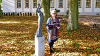 Stadtführerin vor einer Bronzefigur: Sie begleitet die Wanderungen mit ihrem Märchenbuch.