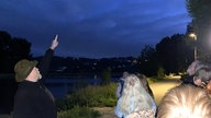 Manfred Kohlstadt zeigt in den Abend-Himmel.