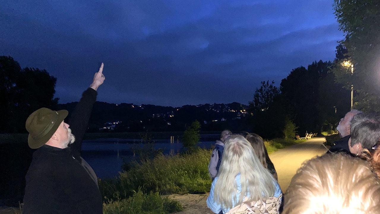Manfred Kohlstadt zeigt in den Abend-Himmel.