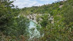 Ausblick auf eine Schlucht mit einem türkisfarbenen See im Tal