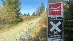 Schild auf einem Wanderweg, auf dem "Rothaarsteig" steht
