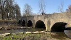 Der Fluss Alme fließt unter einer Brücke her. Man sieht zwei Personen auf der Brücke, weitere Spaziergänger gehen gerade auf die Brücke zu.