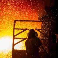 Ein Mitarbeiter reinigt im Stahlwerk der Salzgitter AG eine Roheisenpfanne.