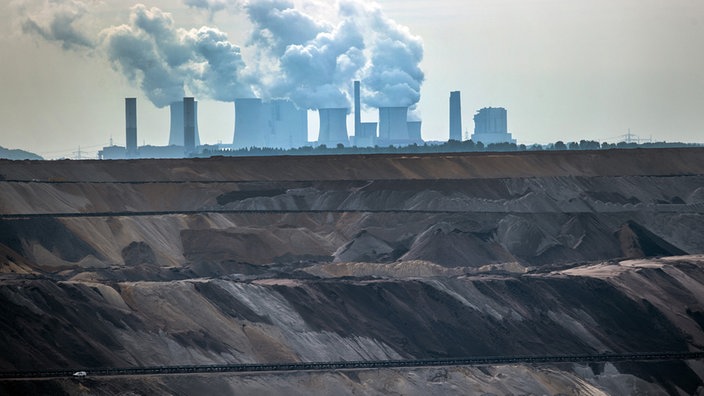 Hinter dem Braunkohletagebau in Garzweiler ist das Braunkohlekraftwerk Neurath zu sehen