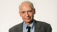 Jens Reich lächelnd mit Akten unter dem Arm