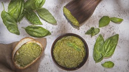 Pesto mit Basilikumblättern geschmückt