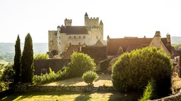 Das Château de Beynac in der Region Périgord in Frankreich in goldenem Sonnenlicht.