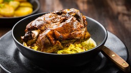 Geschmorte Schweinshaxe mit Wirsing in einer schwarzen Schüssel (Foto kann vom Rezept abweichen, die Red.) 