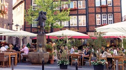 Cafés und die Kiepenkerl-Statue am Spiekerhof in Münster